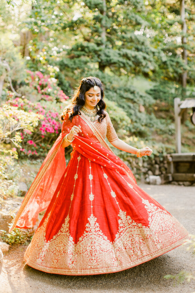 Bride wearing red and gold lehenga at Hakone Gardens