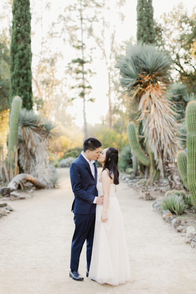 Couple standing among sculptural cacti at Stanford Cactus Garden engagement session