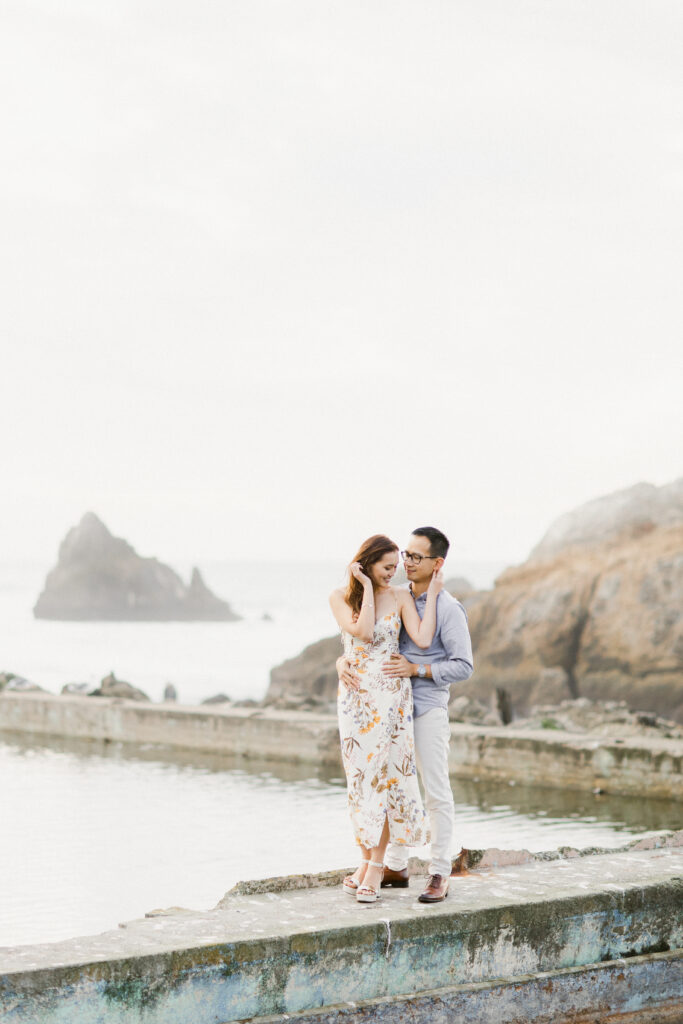 Couple cuddled together near the shoreline