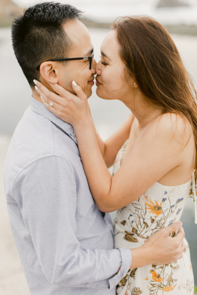 Couple bumping noses during their engagement session along the coast