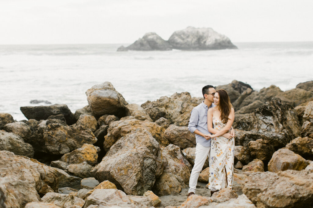 Couple standing close beneath an overcast sky
