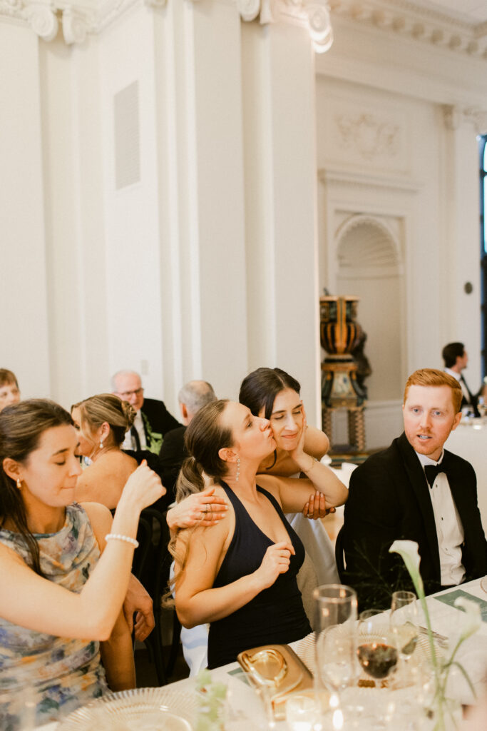 Bride embracing friend at Flood Mansion reception